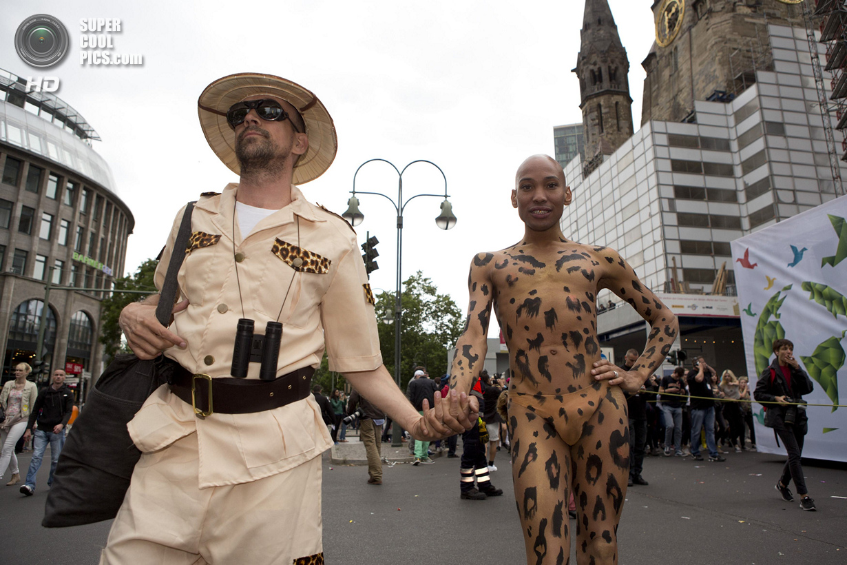 People dressed as a wild animal and a hunter participate in the annual Christopher Street Day parade on Kurfuerstendamm in Berlin